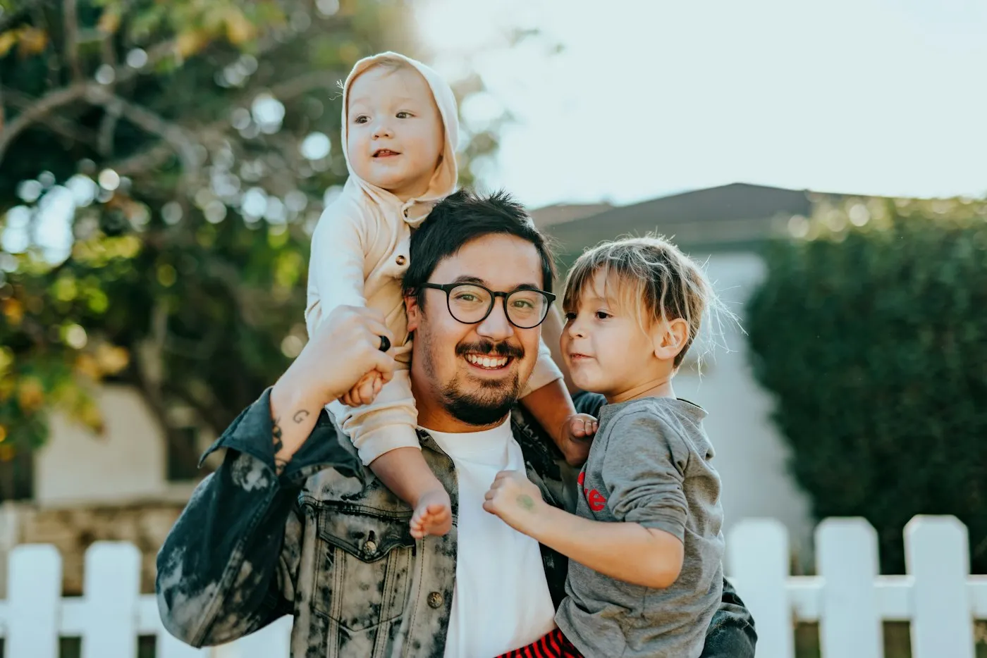 Padre con sus hijos disfrutando el jardín de su casa