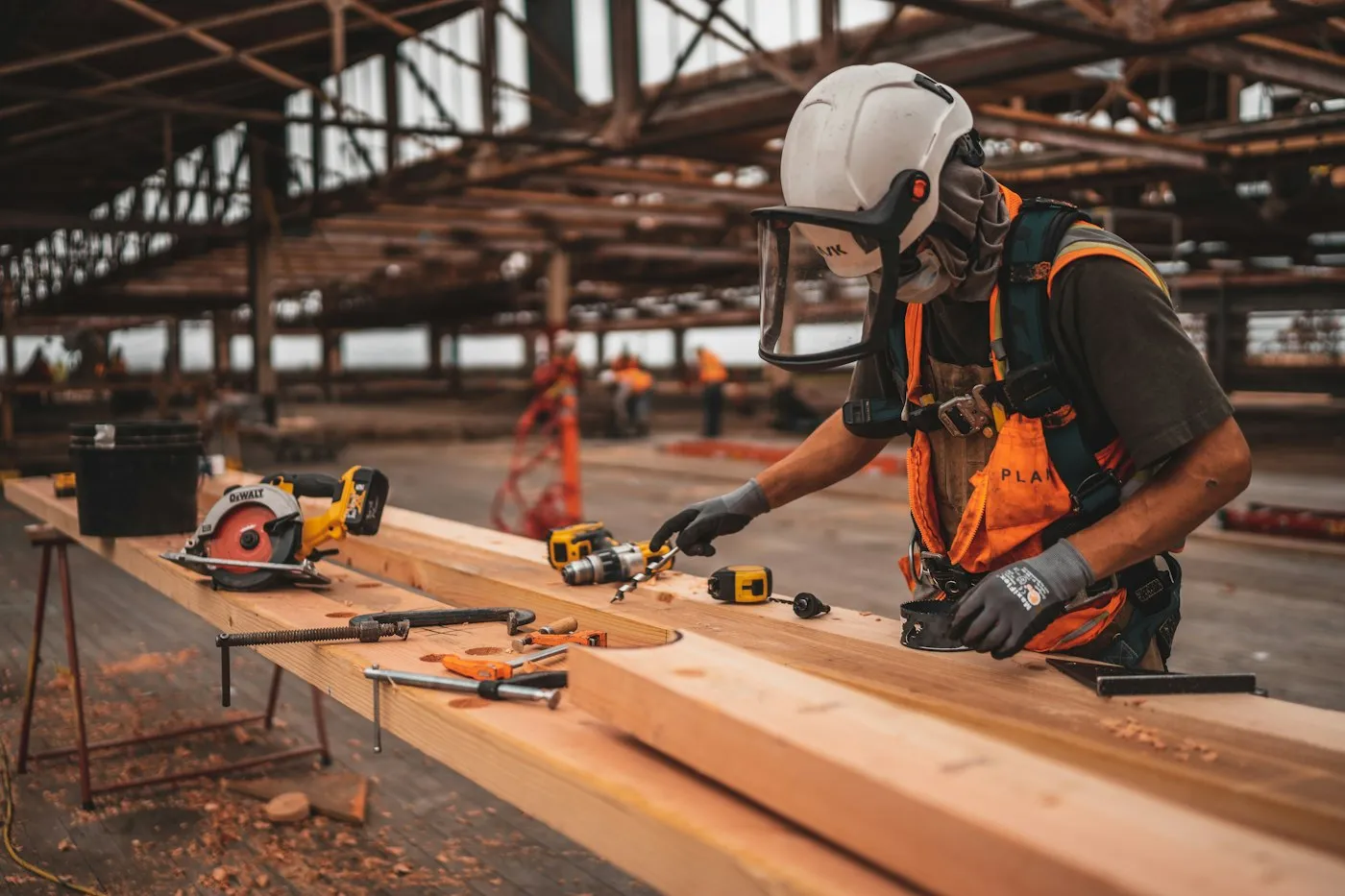Constructor cortando tablas de madera en una obra